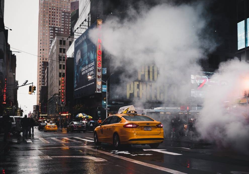 A yellow taxi cab driving down the street